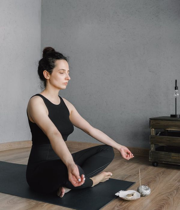 Woman smiling and feeling vibrant in a sunlit room after her morning routine.